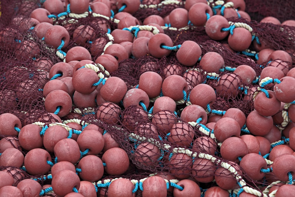 a pile of red balls with blue string on them