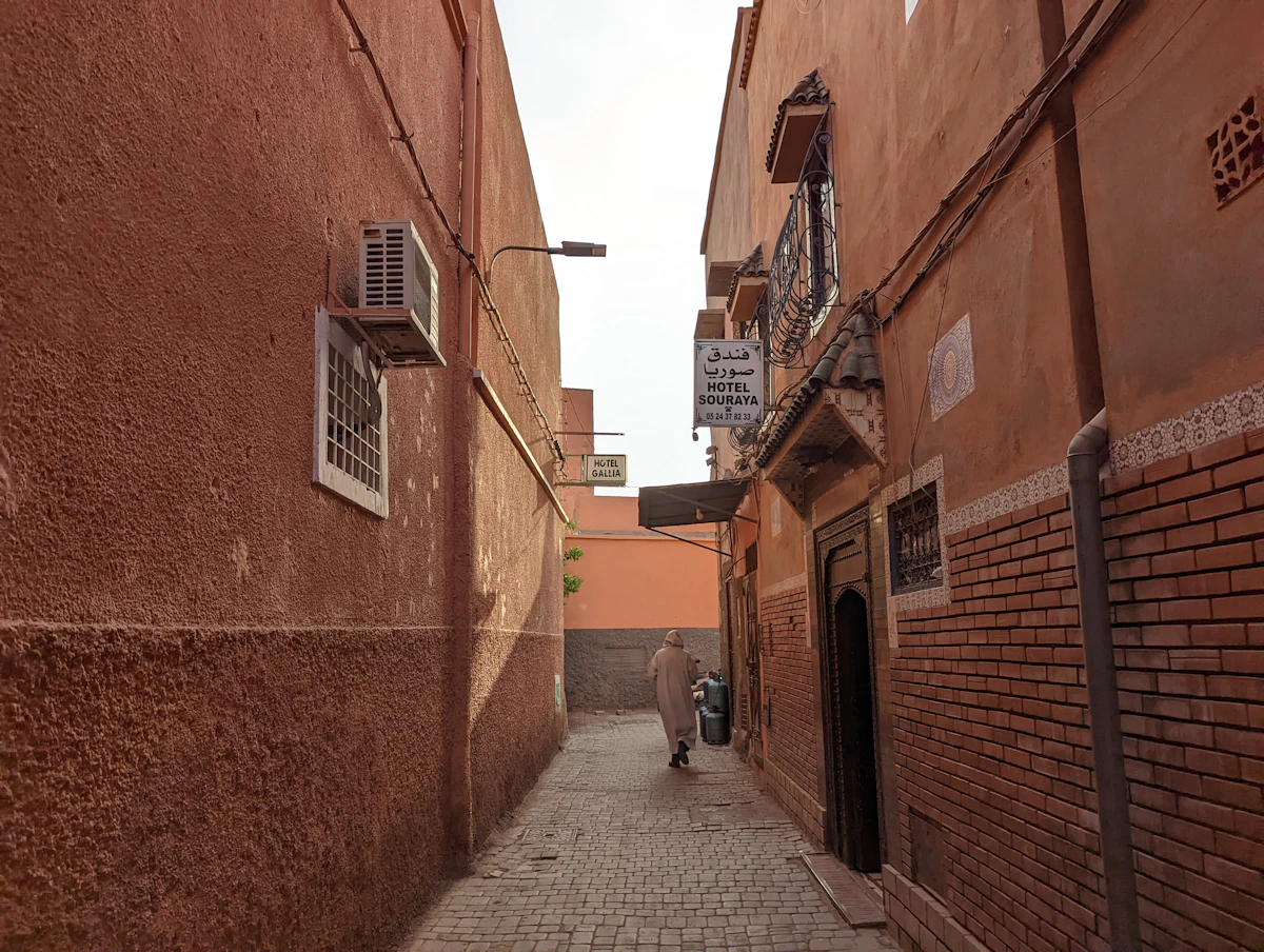 Ruelle de la médina de Marrakech, mur ocre et porte cloutée à l'approche du Riad Zahrat Al Sahara