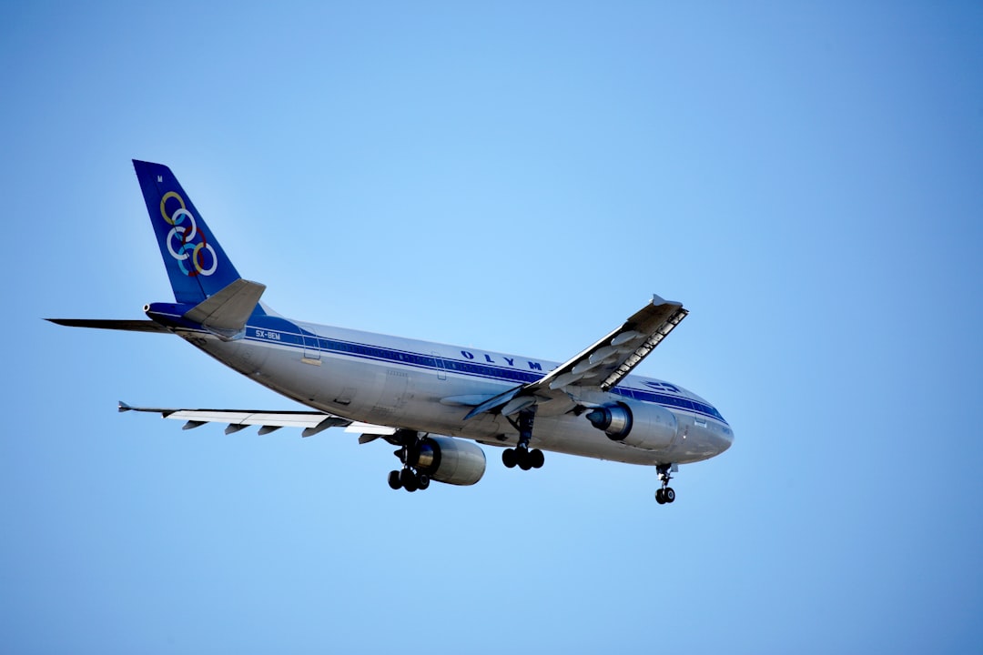 a blue and white jet airliner flying in the sky,