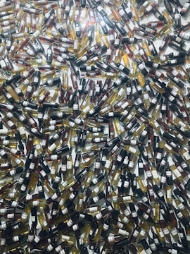 A large number of wine bottles are scattered randomly across the surface, creating a chaotic and colorful pattern. The bottles vary in color, indicating different wine varieties such as red, white, and rosé.