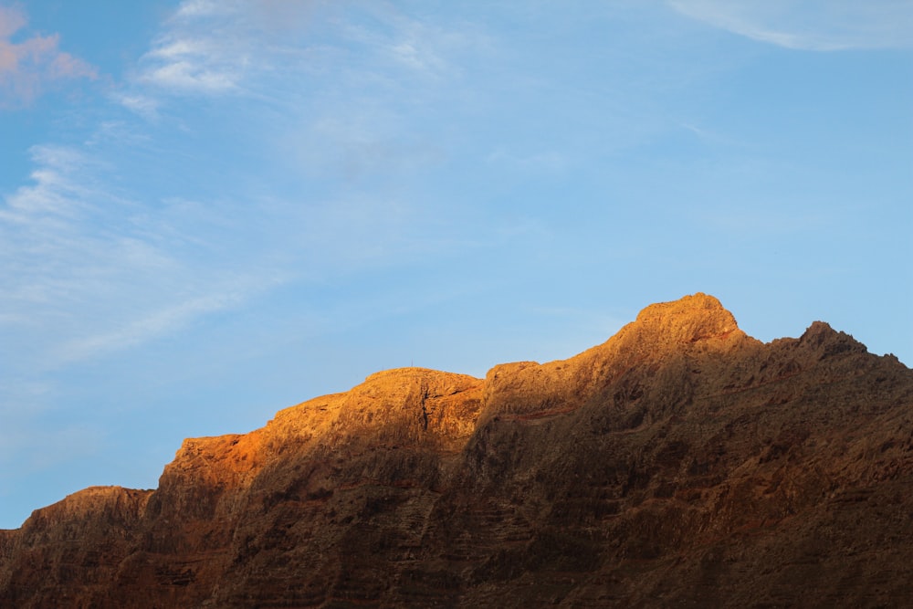 a very tall mountain with a sky in the background