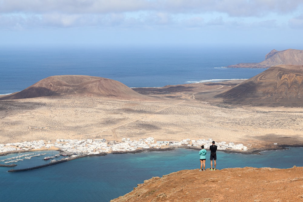 a couple of people standing on top of a hill