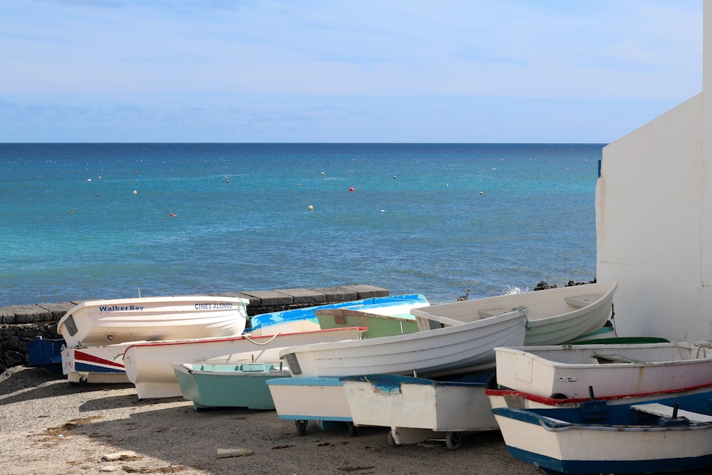 a group of boats sitting on top of a sandy beach