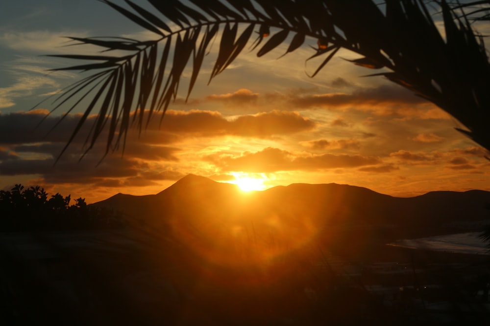 the sun is setting over a mountain range