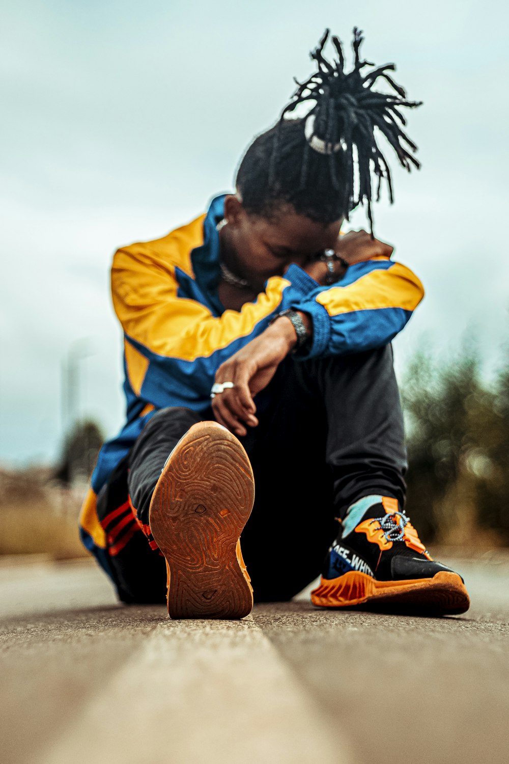 a person with dreadlocks sitting on the ground