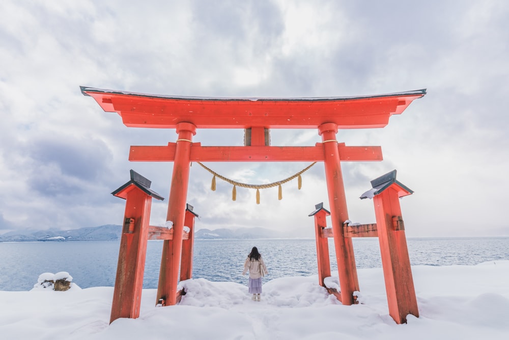 a woman standing under a red tori tori tori tori tori tori tori tori tori tori