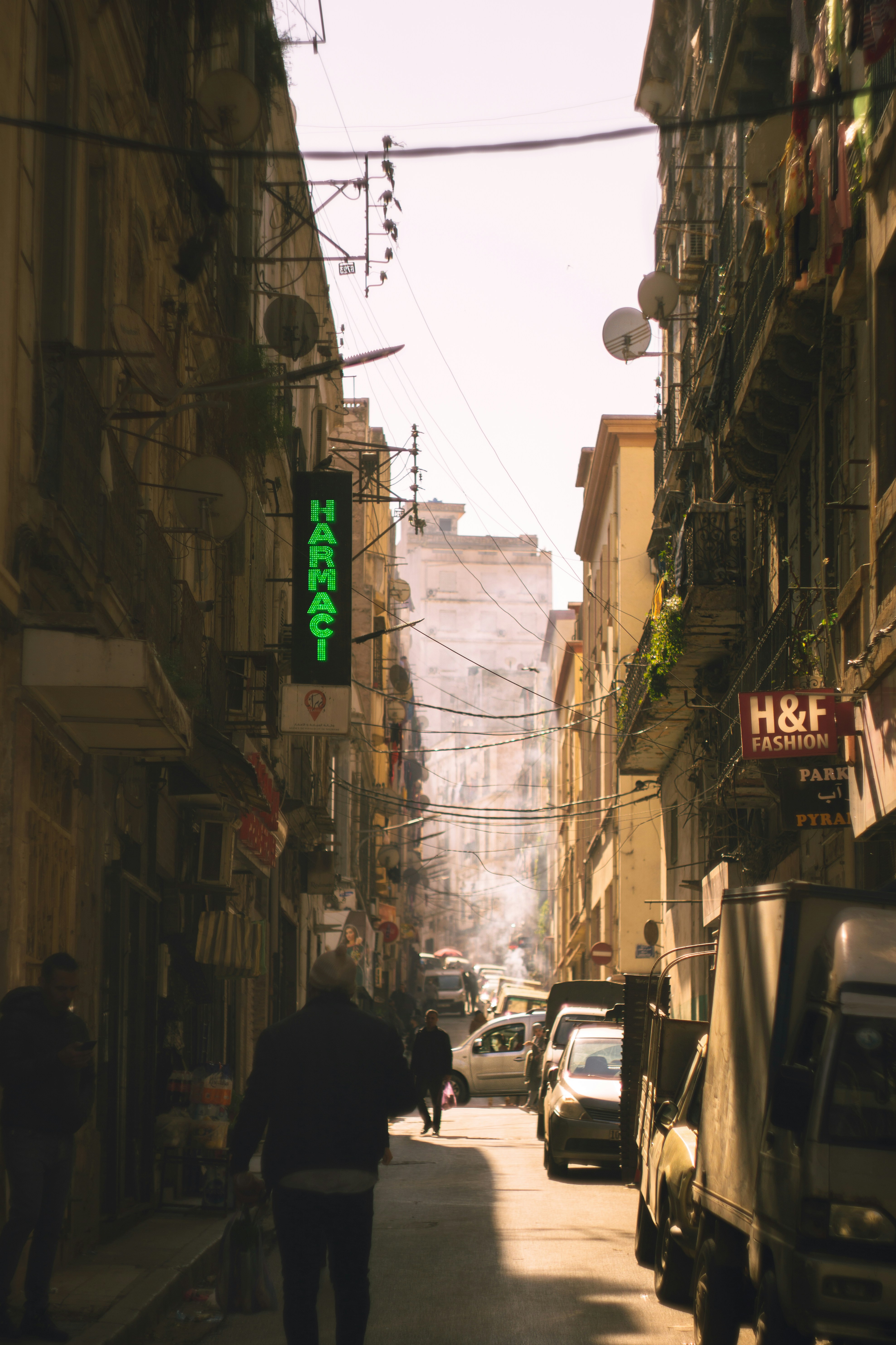 a man walking down a street next to tall buildings