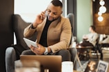 a man sitting in a chair talking on a cell phone