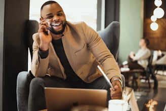a man sitting in a chair talking on a cell phone
