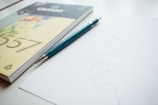 A close-up of hands sketching on a notepad.