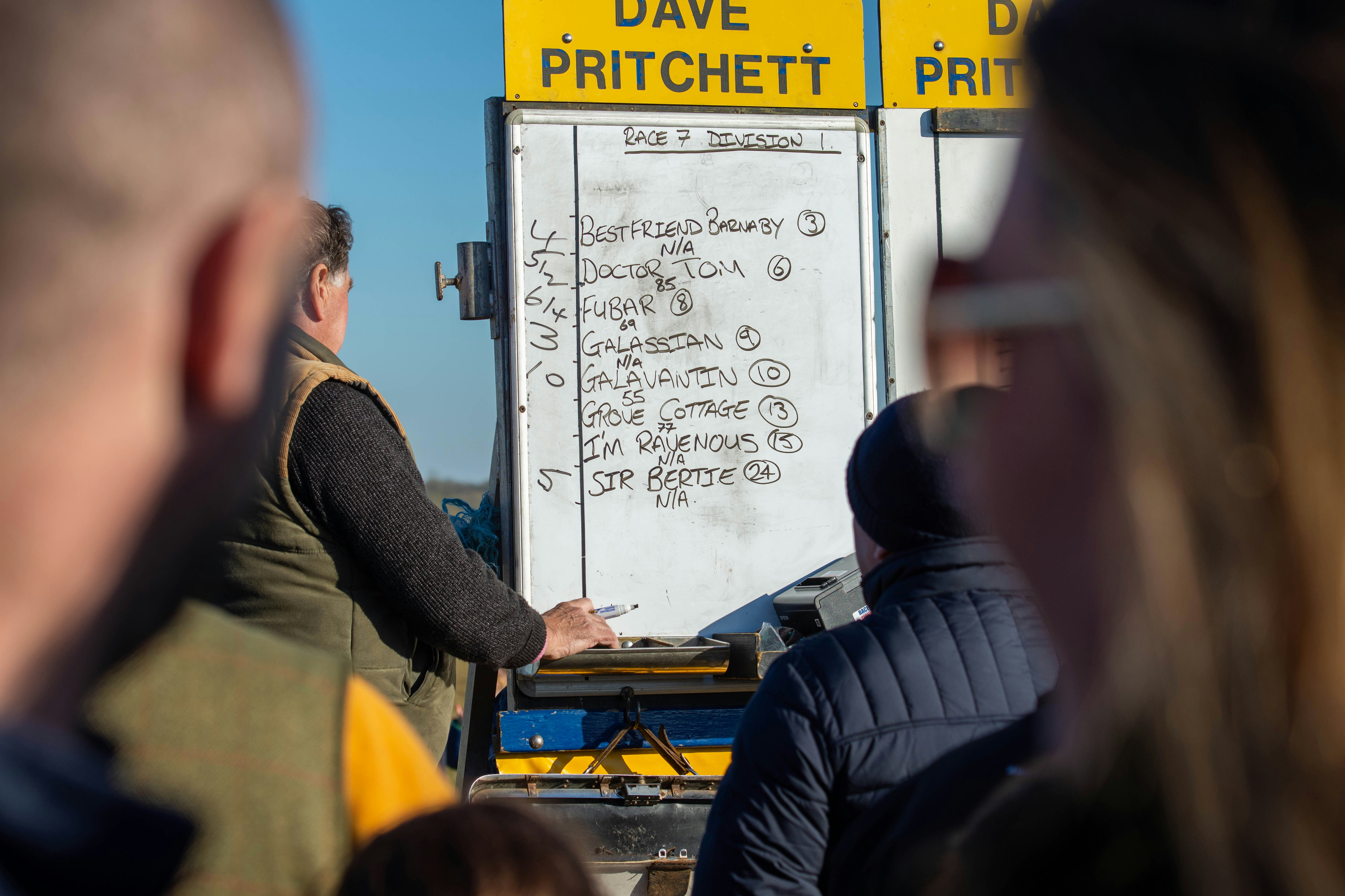 a group of people standing around a white truck