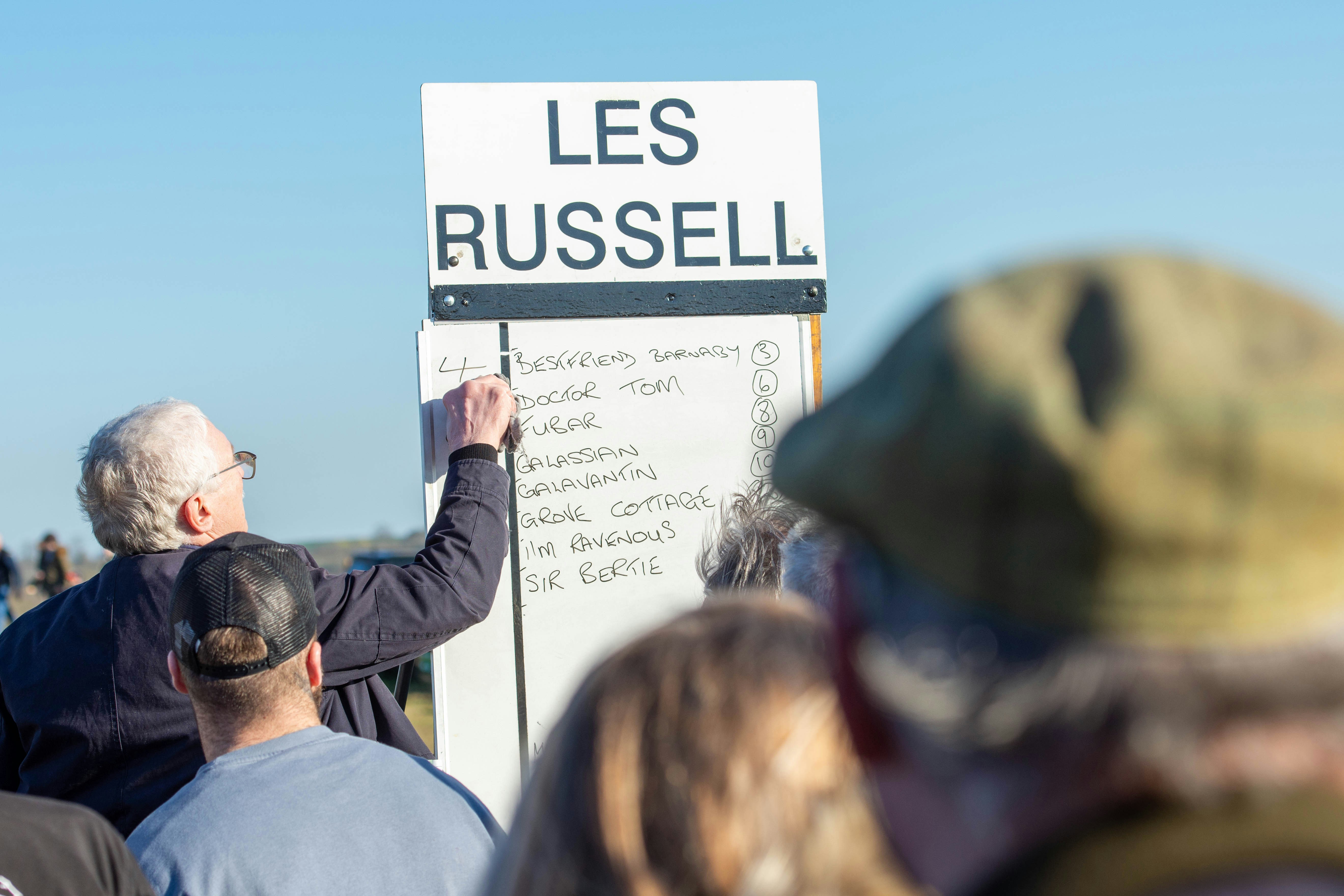 A group of people standing around a sign photo – Free Human Image on ...