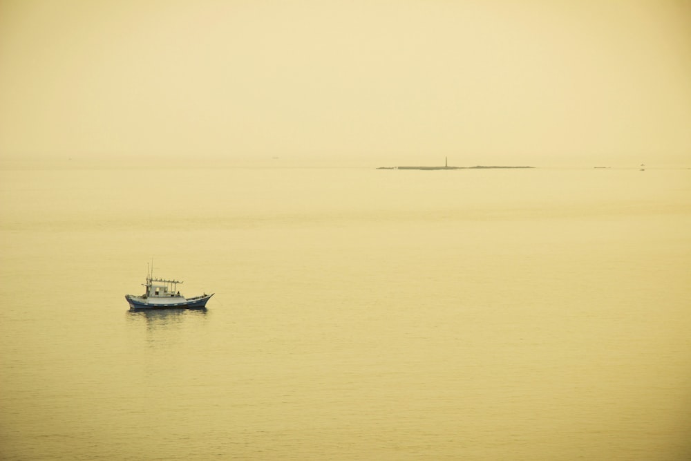 a small boat floating on top of a large body of water