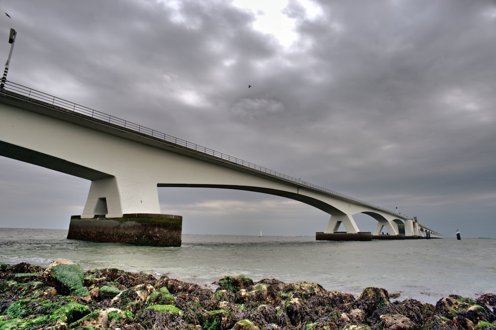 a bridge over a body of water under a cloudy sky