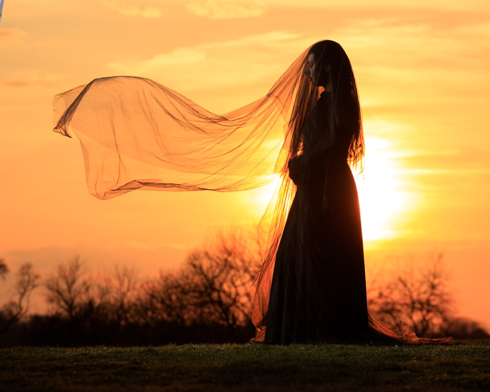 a woman in a long dress with a veil over her head