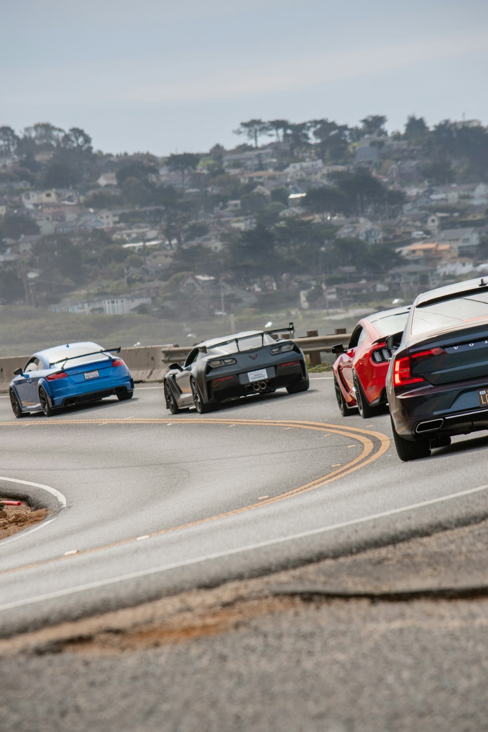 a group of cars driving down a curvy road