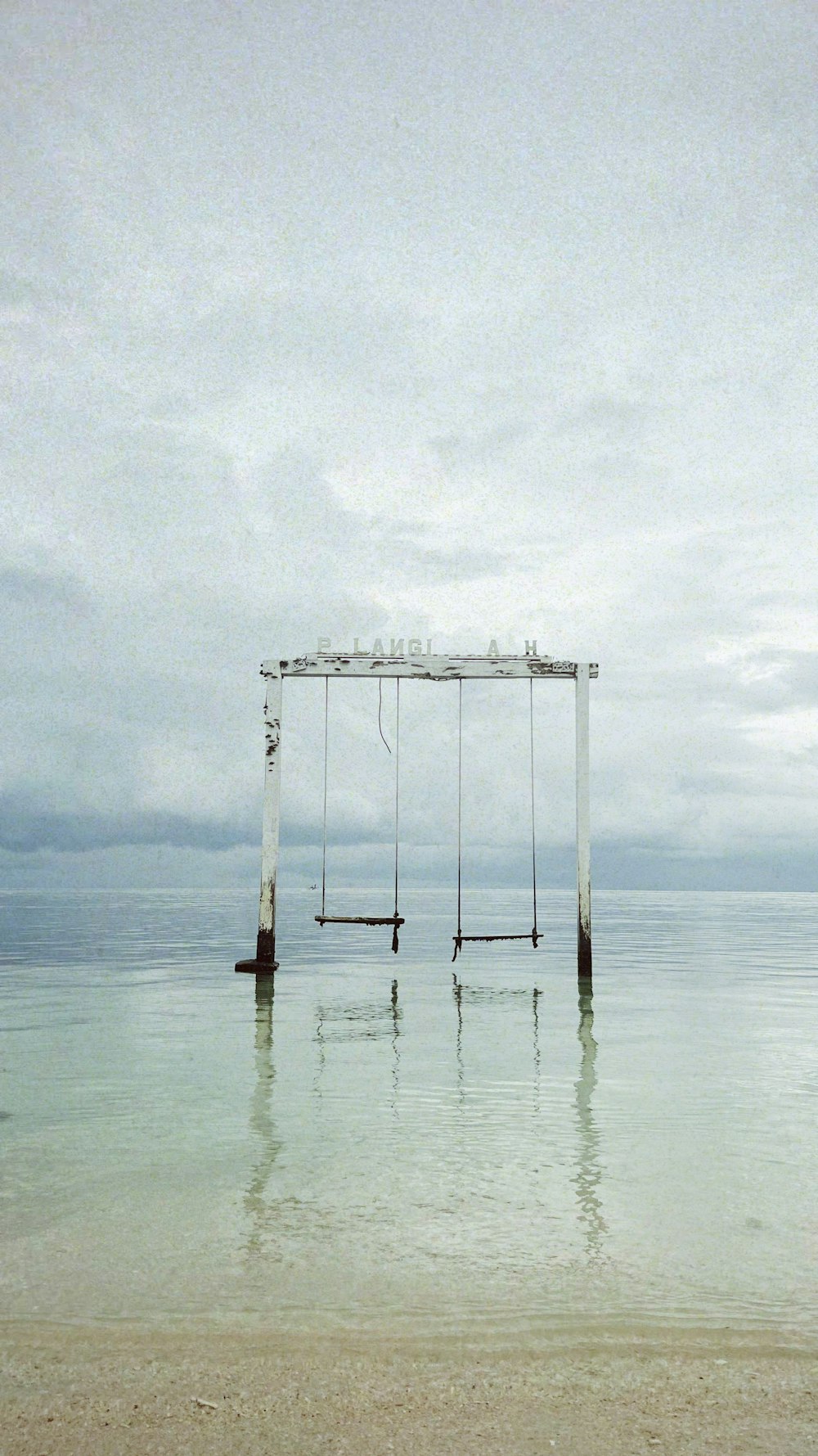 a swing sitting in the middle of a body of water