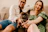 A happy family cuddling their lilac French bulldog puppy in a sunlit Dallas living room.