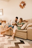 a man and woman sitting on a couch with a dog