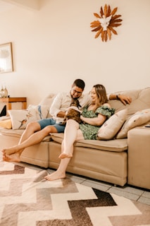 a man and woman sitting on a couch with a dog