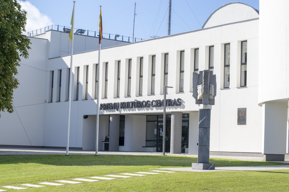 un grande edificio bianco con un'asta della bandiera di fronte ad esso