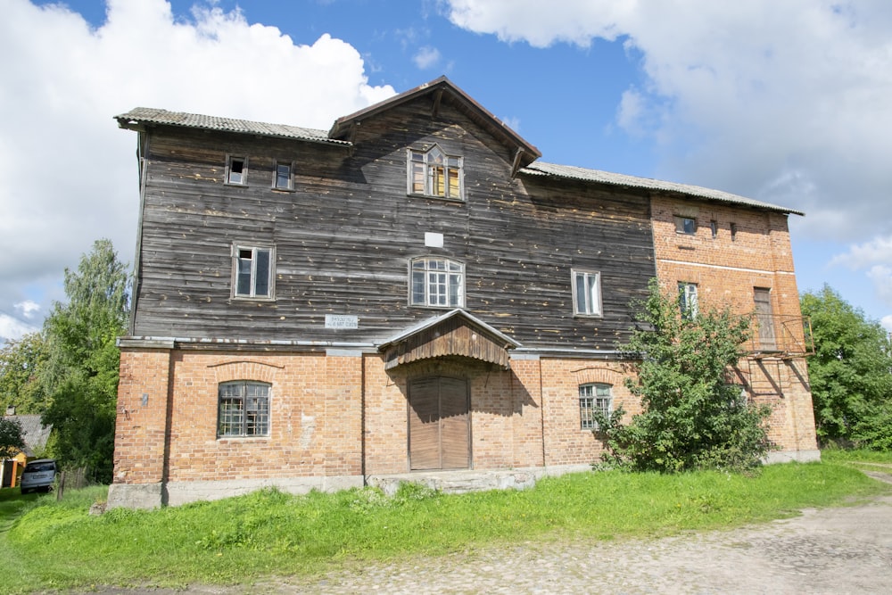 un vecchio edificio in mattoni con una porta e finestre di legno