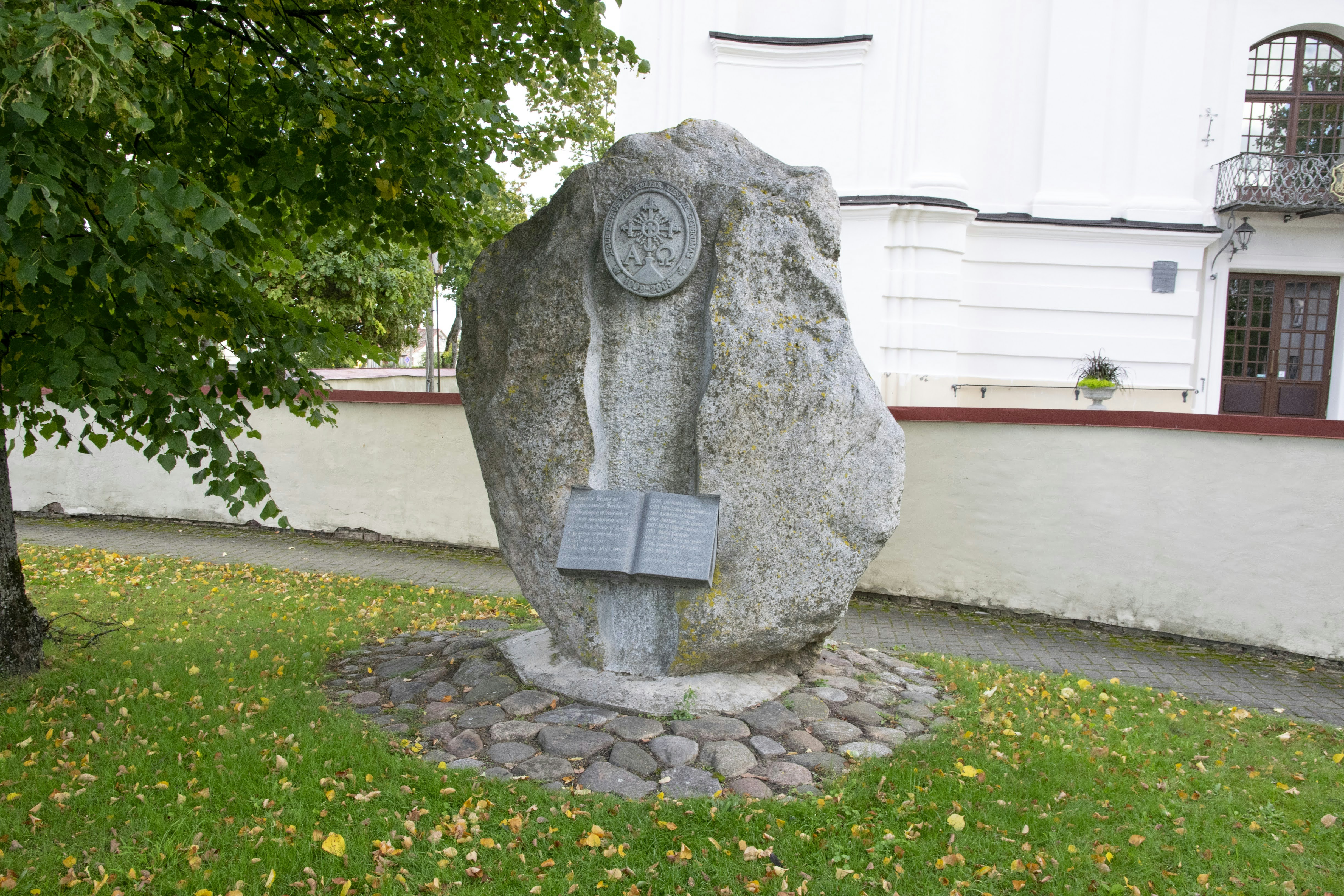 a large rock with a book on it in the grass