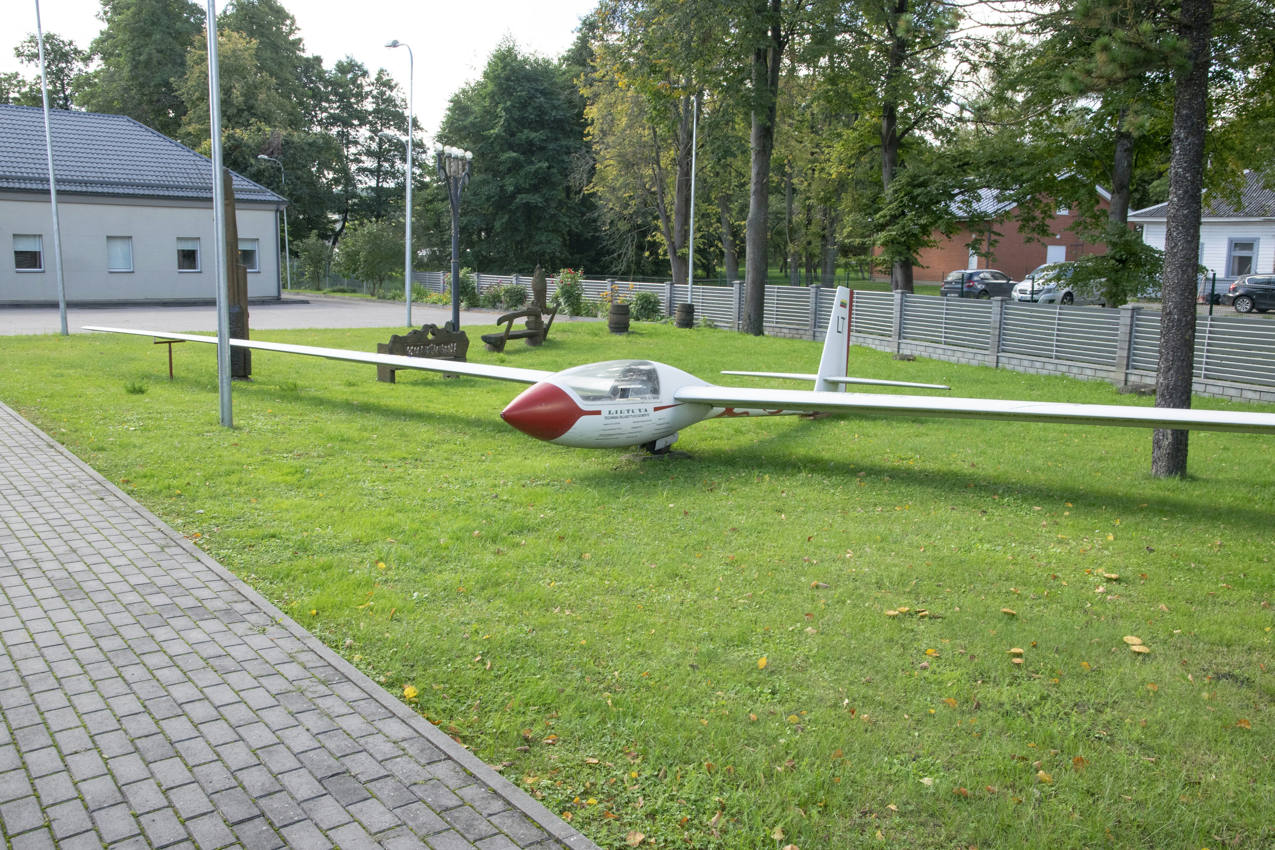 A small airplane sitting on top of a lush green field photo – Free ...