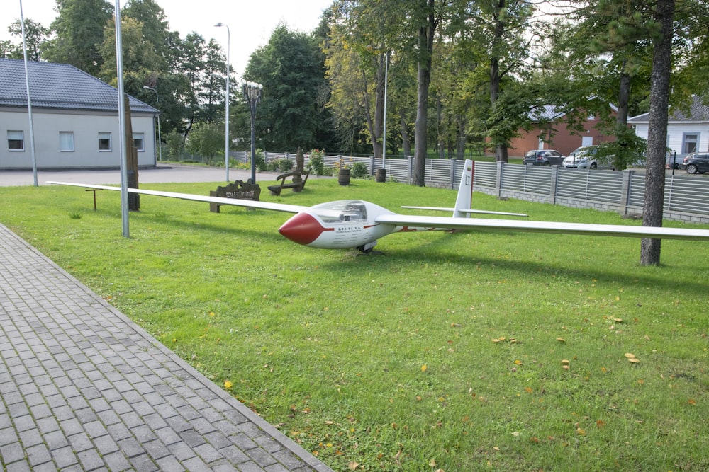 Un piccolo aeroplano seduto in cima a un campo verde lussureggiante