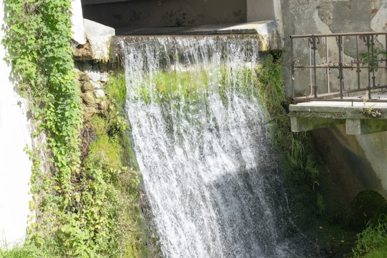 a water fall with a bridge over it