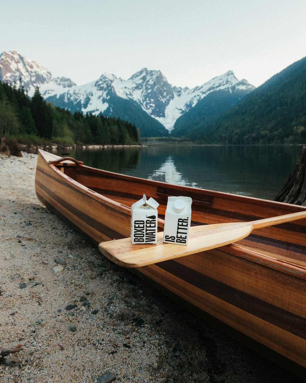 a wooden boat on a lake with mountains in the background