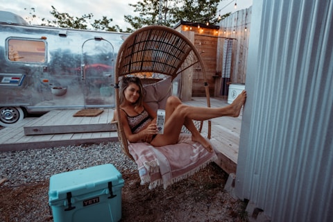 a woman sitting in a chair next to a trailer