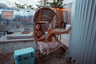 a woman sitting in a chair next to a trailer