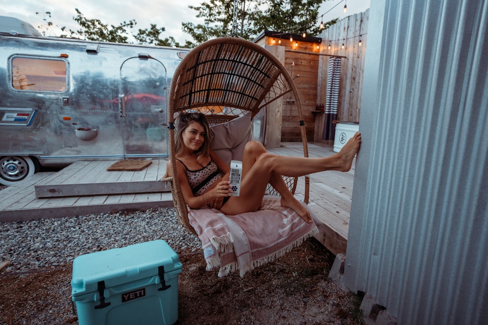 a woman sitting in a chair next to a trailer