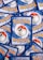 Multiple Pokémon trading cards are scattered, with the back side visible. Each card features a large red and white Pokéball design in the center, surrounded by swirling blue patterns and prominently displaying the Pokémon logo in bright yellow lettering.