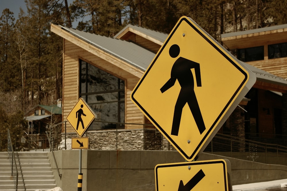 a yellow pedestrian crossing sign in front of a house