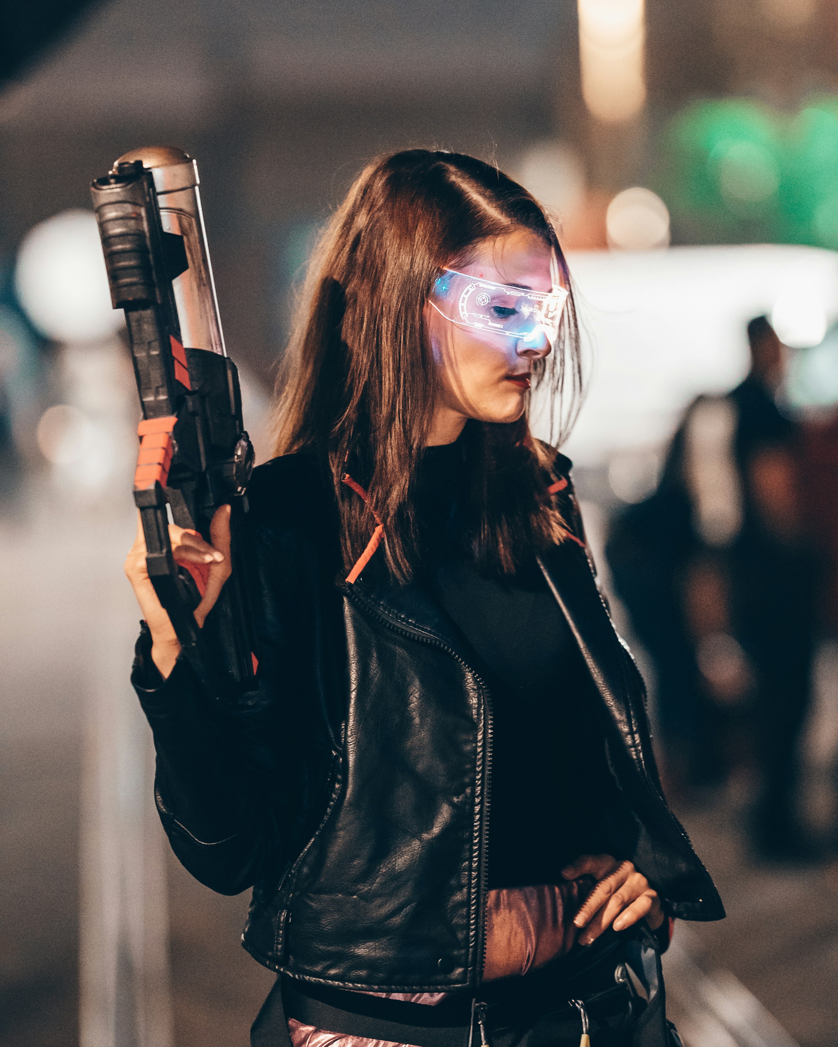 Seorang wanita berjaket kulit memegang pistol