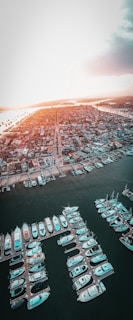 A stunning aerial view of Marina del Rey's waterfront homes at sunset, with boats docked along the piers.