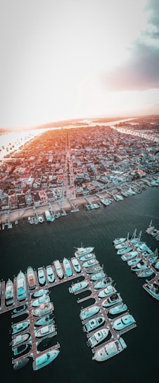 A stunning aerial view of Marina del Rey's waterfront homes at sunset, with boats docked along the piers.