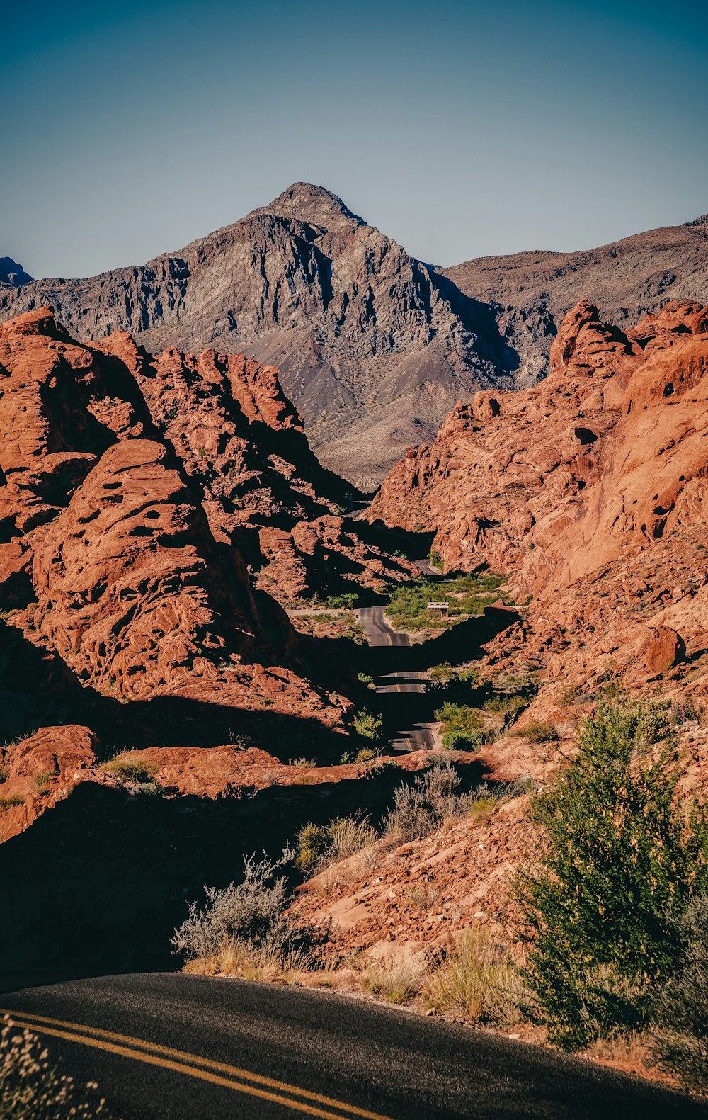 a road in the middle of a desert with mountains in the background