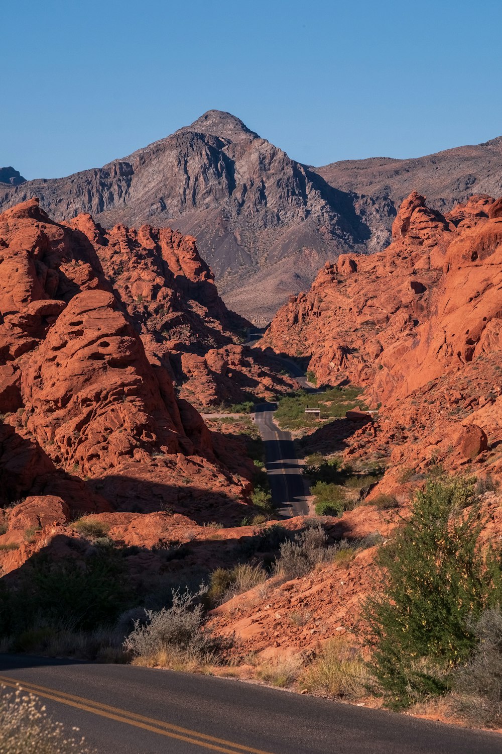 a road in the middle of a desert with mountains in the background