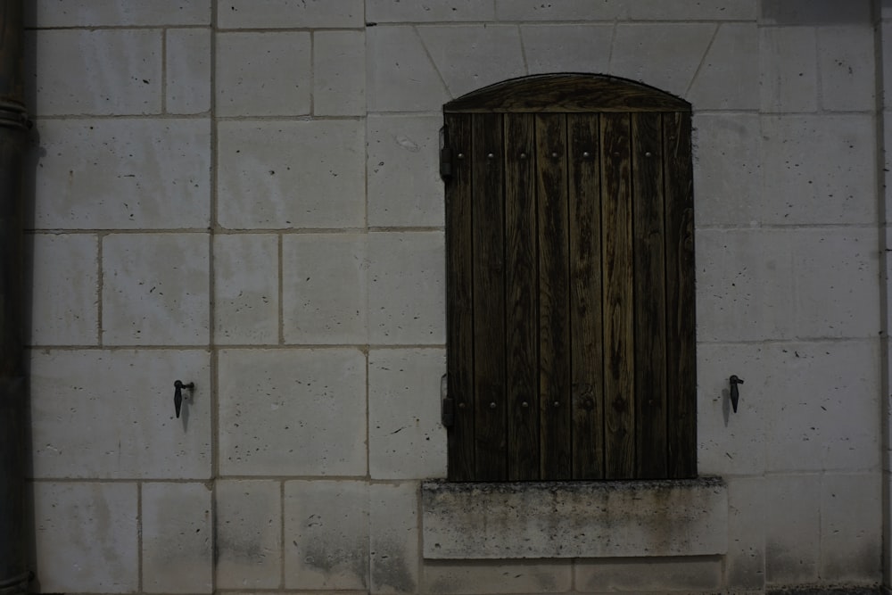 una ventana de madera en una pared de ladrillo blanco