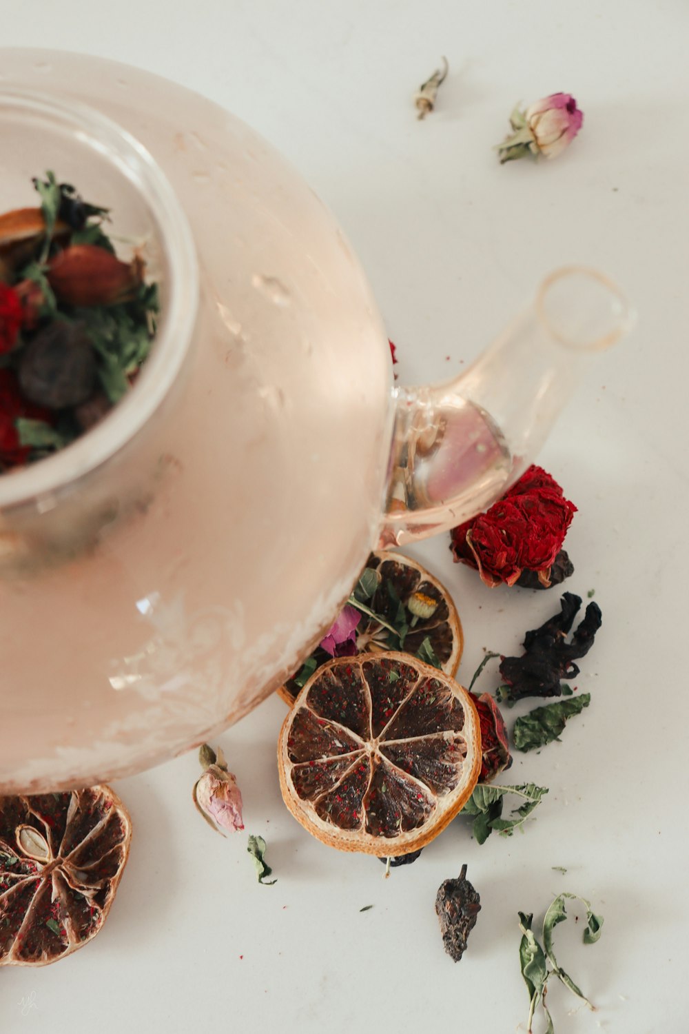 a tea pot filled with orange slices and dried flowers
