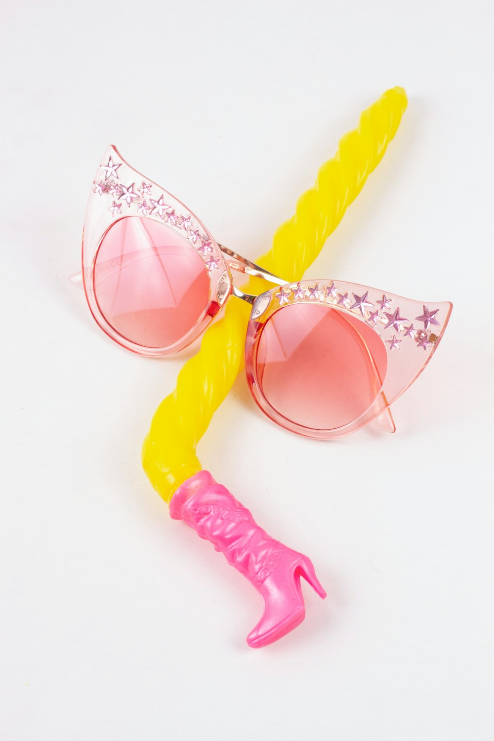 um par de óculos de sol cor-de-rosa com uma alça amarela