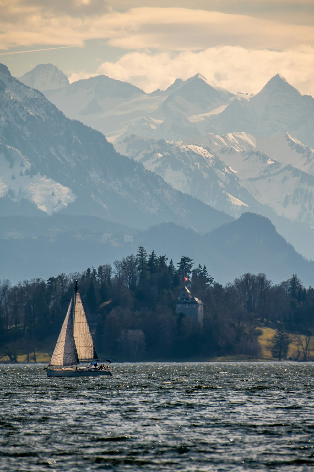 a sailboat on a lake with mountains in the background