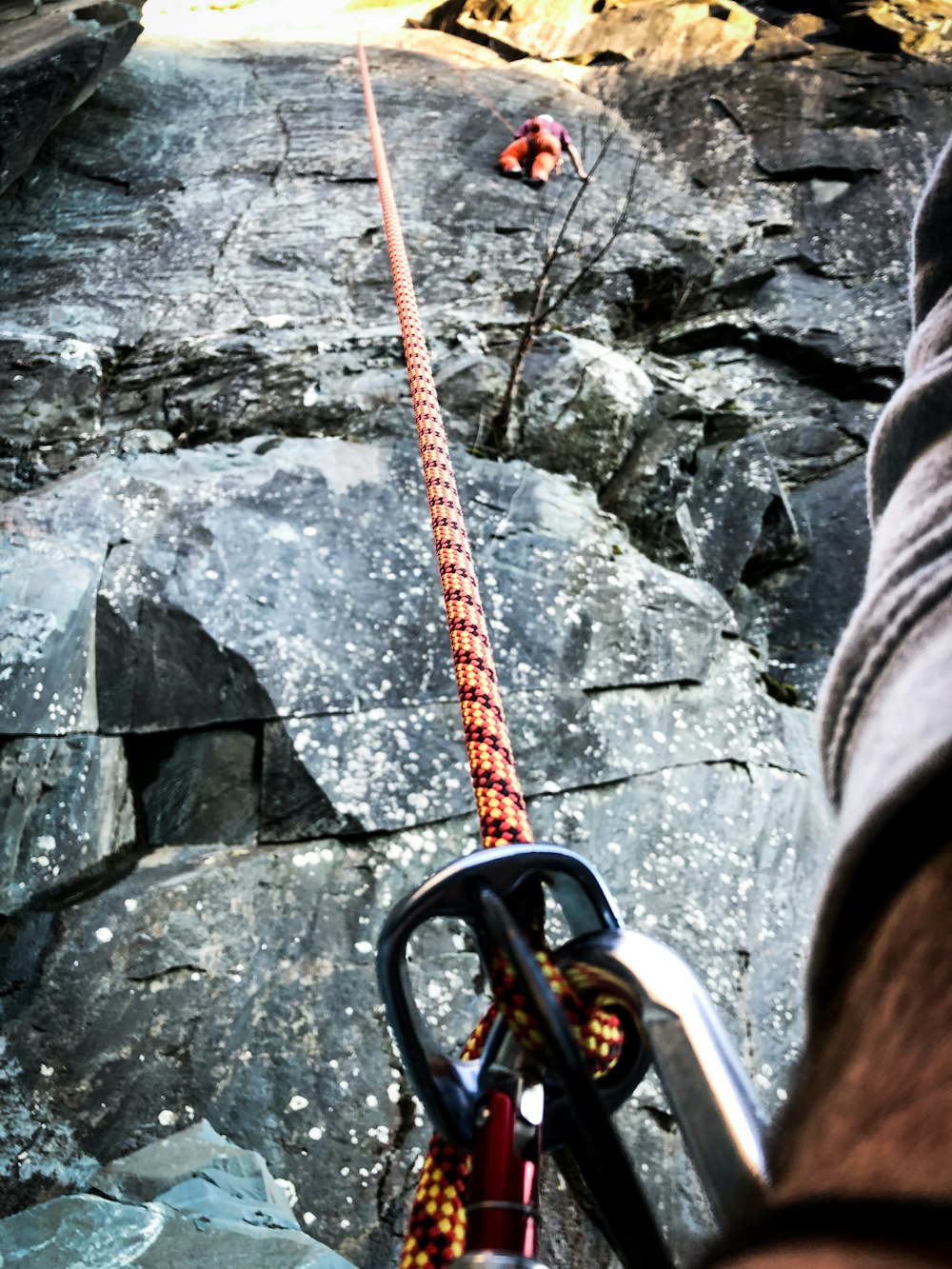 a man is climbing up a mountain with a rope