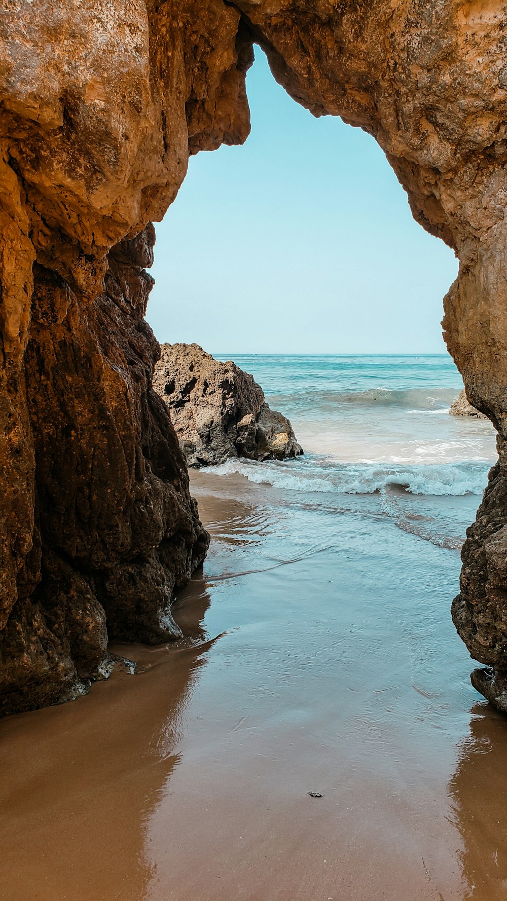 a view of the ocean through a cave