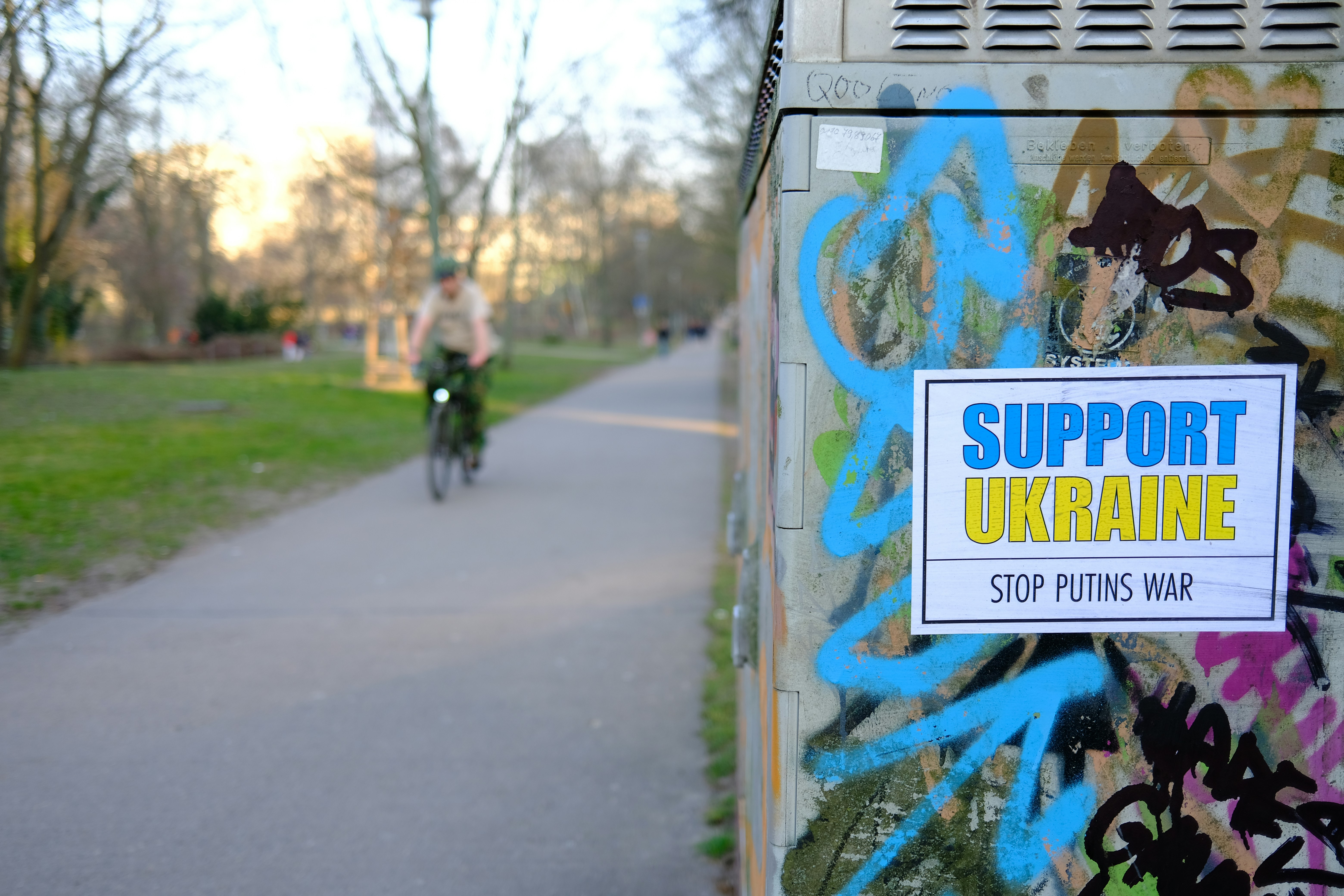 a person riding a bike past a graffiti covered wall