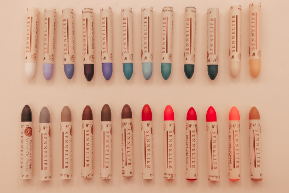 a group of different colored lipsticks lined up in a row