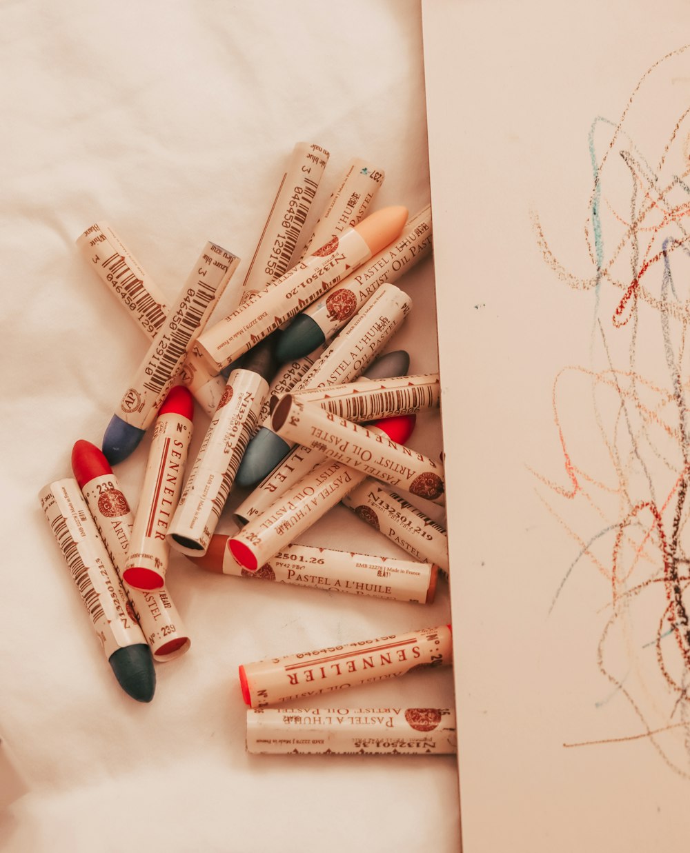 a pile of crayons sitting on top of a sheet of paper